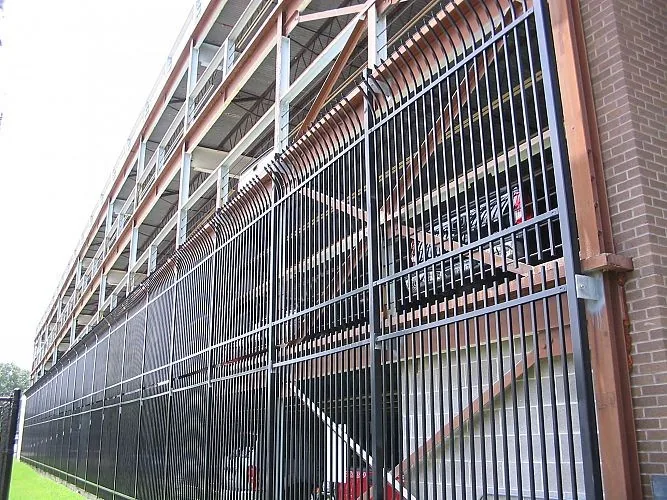 Bent top metal fence installed along a building facade