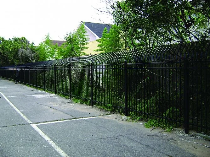 Curved top steel fence installed along a utility boundary