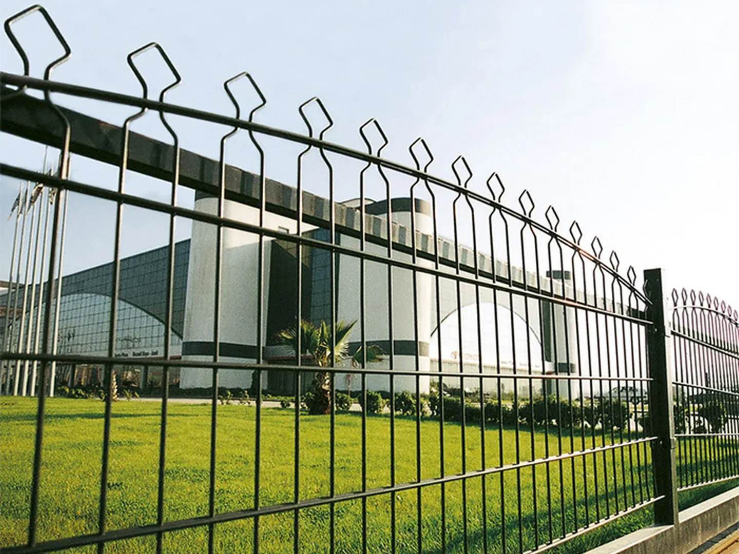 Green powder coated double wire fence finish shown beside a public perimeter scene